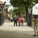 Toeristen voor het de poort Arbeit macht frei. Collectie: Hans Citroen