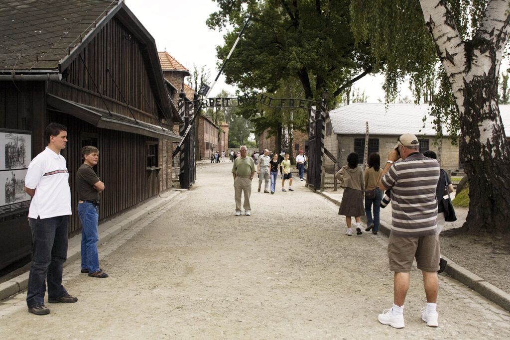 Touristes devant la porte Arbeit macht frei. Collection : Hans Citroen