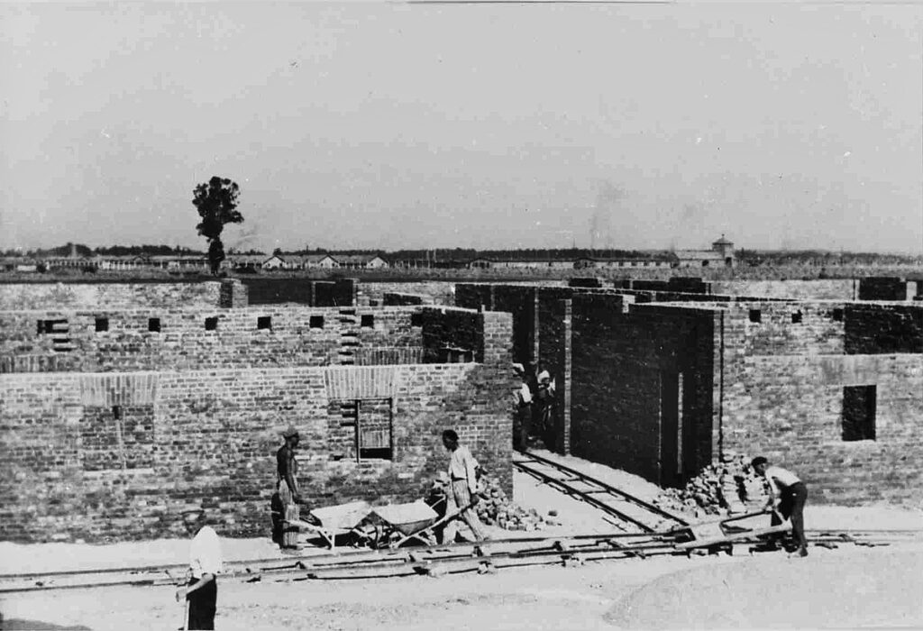 The construction of the Kartoffellagerhallen in the summer of 1942. On the horizon the gatehouse of the Birkenau concentration camp. Collection: Panstwowe Muzeum Auschwitz-Birkenau